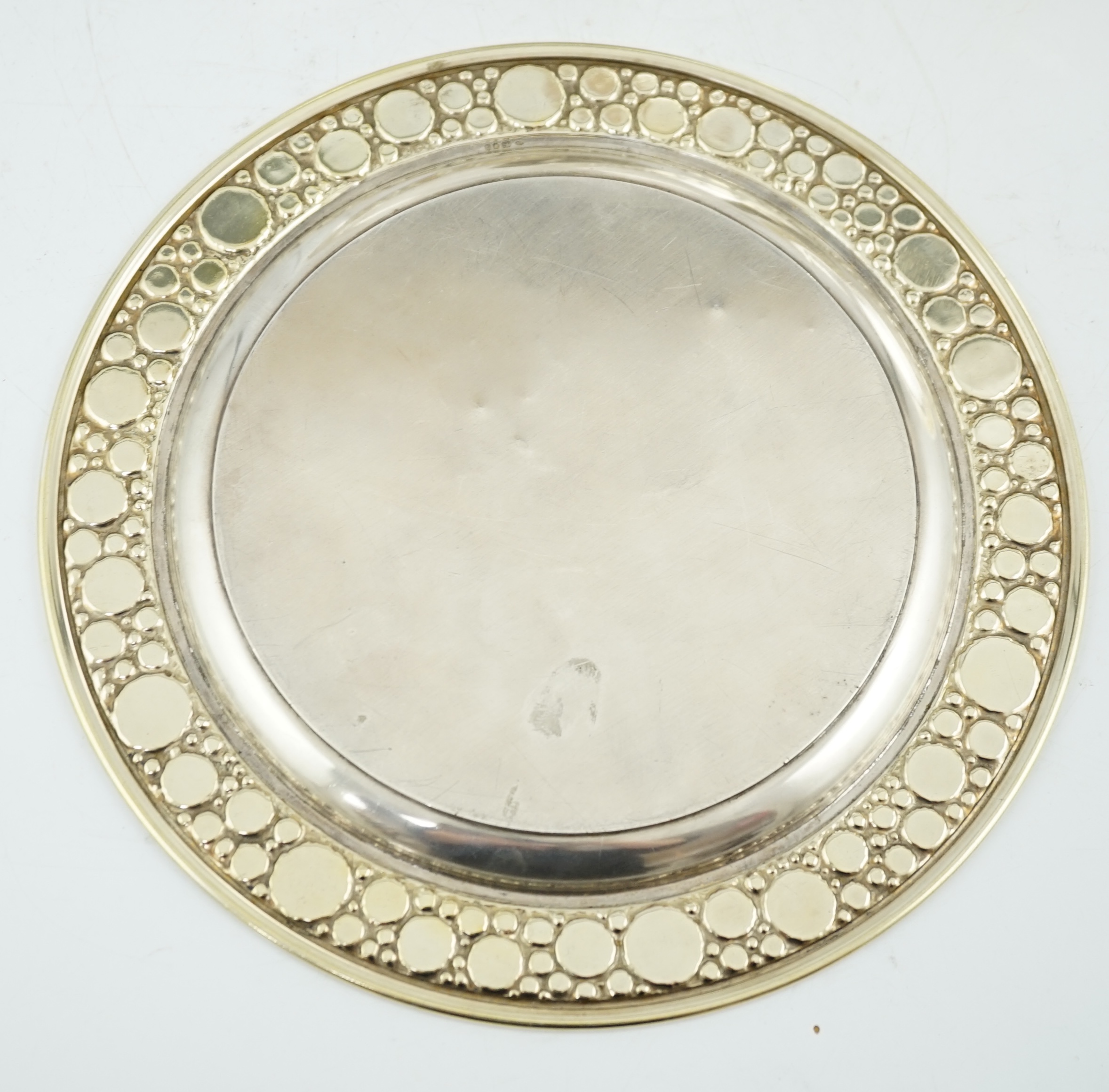 A set of four Elizabeth II Stuart Devlin parcel gilt silver circular plates